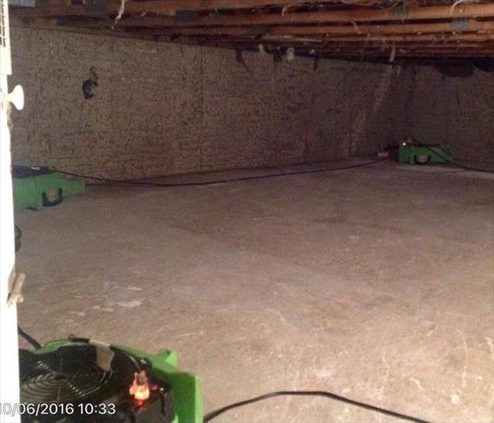 Air movers placed along the floor of the basement after water has been extracted. 