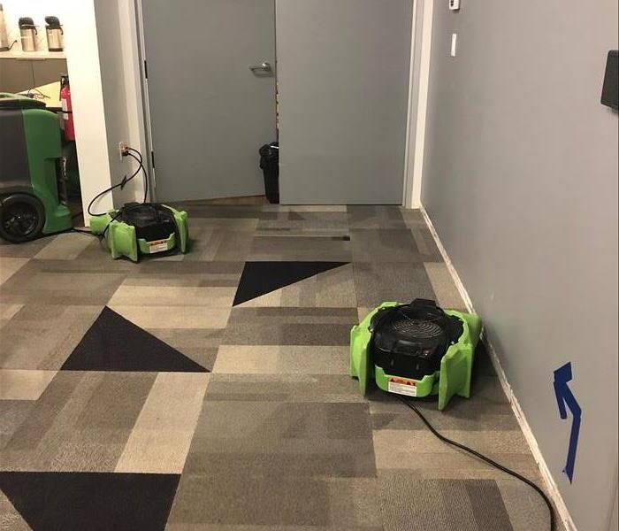 Air movers along carpet in building office. 
