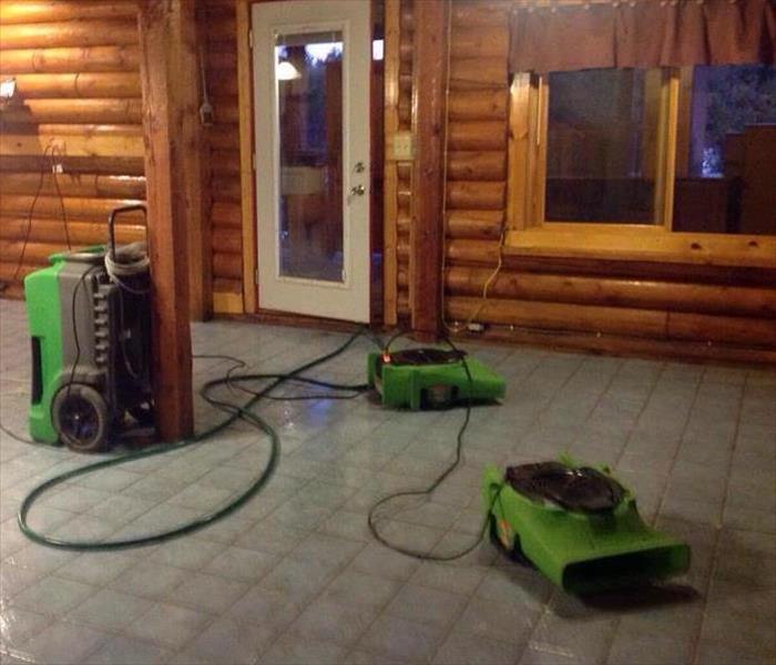 Wooden cabin with exposed tile floor and air movers. 