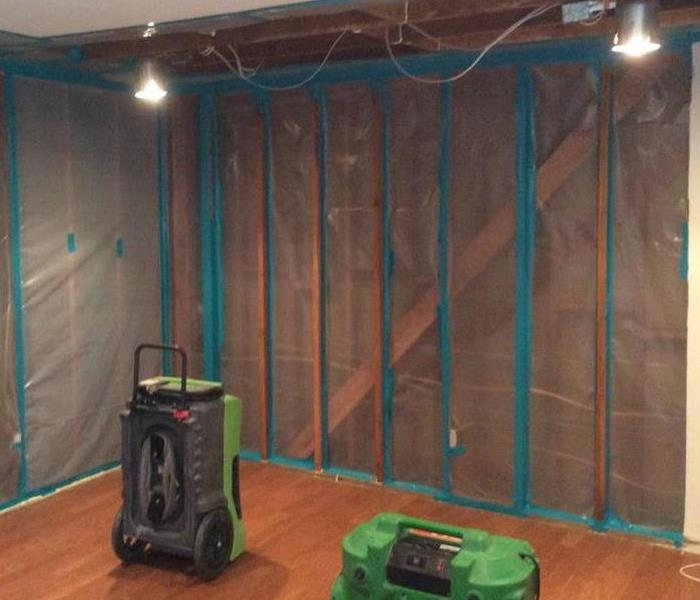 Living room with plastic walls and equipment on the floor. 