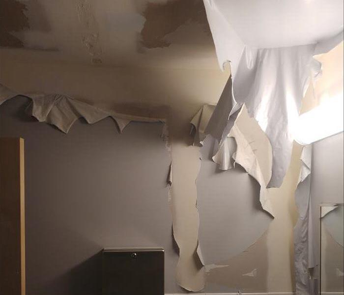 Wall paper in boys restroom is ruined after a pipe broke inside the wall. 